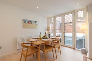 a dining room with a wooden table and chairs at Sandy Castle in Southwold