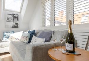 a bottle of wine and two wine glasses on a table at Sandy Castle in Southwold +13 photos