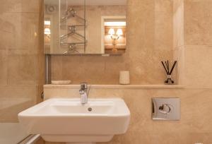 a bathroom with a white sink and a mirror at Sandy Castle in Southwold
