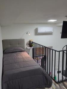 1 dormitorio con cama y barandilla para escaleras en La bomboniera di Dante, en Nápoles