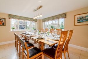 a dining room with a long wooden table and chairs at Milestone in Winchcombe