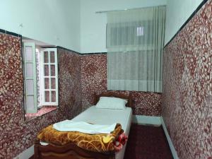 a small bedroom with a bed and a window at Dar Ba sidi in Rabat
