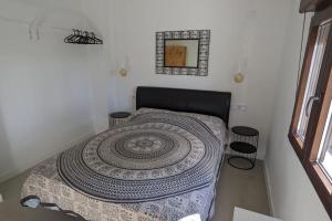Un dormitorio con una cama con un adorno. en Casita de la Higuera, en Jávea