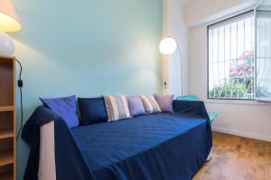 a blue couch in a room with a window at Promenade des Anglais 2 Bdr Large Terrace in Nice