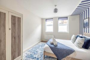 een slaapkamer met een bed met een blauw tapijt bij Central Windsor 1BR Gem in Windsor