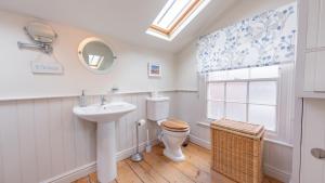 ein Badezimmer mit Toilette und Waschbecken und einem Fenster in der Unterkunft Palmer's Cottage in Southwold + 9 Fotos