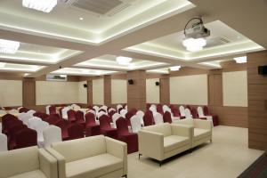 een vergaderzaal met rode stoelen en witte stoelen bij HOTEL CARNIVAL in Parbhani