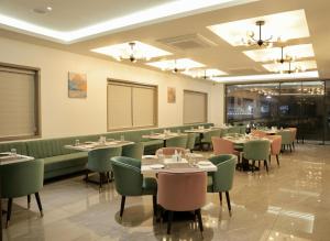 a dining room with tables and green chairs at HOTEL CARNIVAL in Parbhani