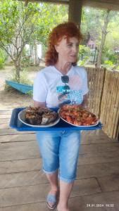 een vrouw met een dienblad eten op een tafel bij Lake Lane Guest Rest in Koggala