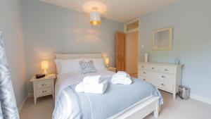 ein Schlafzimmer mit einem Bett mit zwei Handtüchern darauf in der Unterkunft Palmer's Cottage in Southwold