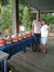 a man and woman standing next to a table with clay pots at Lake Lane Guest Rest in Koggala