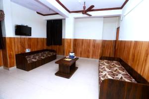 a room with a couch and a table and a tv at New Jain Residency Inn Madhya Pradesh in Pachmarhī