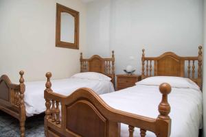 sypialnia z 2 łóżkami i lustrem na ścianie w obiekcie El Olivar Agloipe Ahigal TRCC w mieście Ahigal