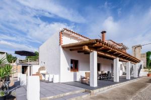 a white house with a patio with a roof at Mallorca - Can Picafort - Finca Dos Amigos in Muro