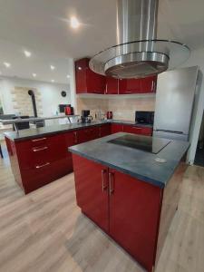 cocina con armarios rojos y encimera azul en Maison l'Escale du port, en Berville-sur-Mer