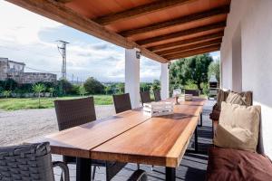 Une table et des chaises en bois sont disponibles sur la terrasse. dans l'établissement Mallorca - Can Picafort - Finca Dos Amigos, à Muro