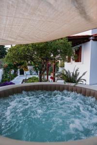 a hot tub in a backyard with an umbrella at Villa Sea View Gem Steps to Zia Square Hot Tub in Lagoúdi Zía