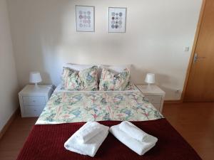 a bedroom with a bed with two white socks on it at Casinha Miradouro in Vila Nova de Gaia