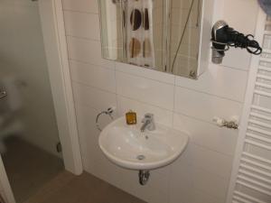 a white sink in a bathroom with a mirror at Ferienhof Arold Wohnung mit 2 Schlafzimmern in Creglingen
