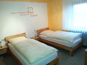 duas camas num quarto com uma placa na parede em Monteurwohnung Ferienhof Arold em Creglingen