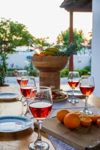 a table with glasses of wine and food on it at Villa Sea View Gem Steps to Zia Square Hot Tub in Lagoúdi Zía