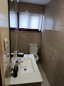 ein Badezimmer mit einem weißen Waschbecken und einem WC in der Unterkunft Casinha Miradouro in Vila Nova de Gaia