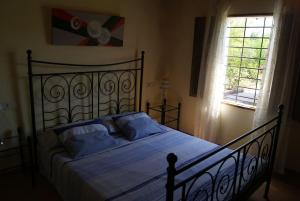 Un dormitorio con una cama con almohadas azules y una ventana en Son Ribes en Alaró