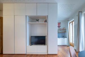 una sala de estar con un gran armario blanco con TV en Refugio de paz y encanto en el corazón de Vigo by Prishomes, en Vigo