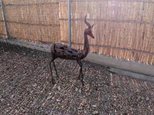 a statue of a bird standing next to a fence at Klein Parys in Parys