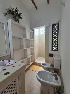bagno bianco con lavandino e servizi igienici di Villa Yasmin a Watamu