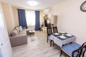 Una sala de estar con un sofá, una mesa y sillas. en Topalov, en Sandanski