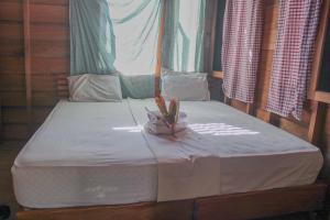 a small bed in a wooden room with at Toro Simalatcat Surfcamp in Masokut