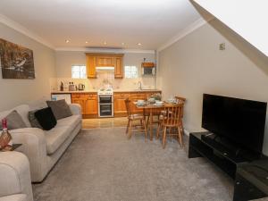 a living room with a couch and a table at Foxglove Cottage in Richmond