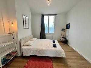 um quarto com uma cama branca e uma janela em Le cocon des cloutiers - Central & Moyen séjour em Liège
