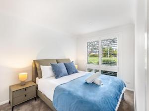 Un dormitorio con una cama grande y una ventana. en Riverfront Oasis Spacious 5BR Luxury w 10m Pool, en East Hills 28 fotos más