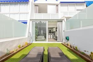 un patio interior de un edificio con dos bancos en Villa Alessandra, Your Private Garden! en Maspalomas