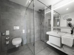 ein Bad mit einem WC, einem Waschbecken und einer Dusche in der Unterkunft Grimm's Potsdamer Platz in Berlin