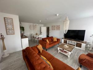 - un salon avec deux canapés et une télévision dans l'établissement TOP appartement met garage "Au Franelle", à Ostende