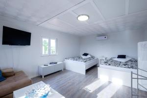a white room with two beds and a couch at Mallorca - Can Picafort - Finca Dos Amigos in Muro +50 photos