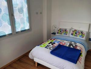 um pequeno quarto com uma cama com almofadas coloridas em Sleep & Fly Villa Luisa em Case Nuove