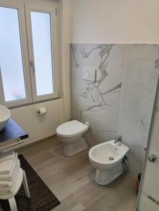 bagno bianco con servizi igienici e lavandino di Sleep & Fly Villa Luisa a Case Nuove