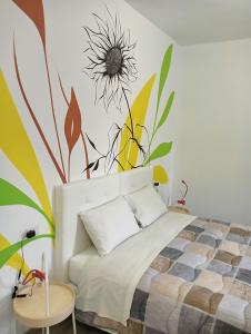 a bedroom with a bed with a flower mural on the wall at Sleep & Fly Villa Luisa in Case Nuove