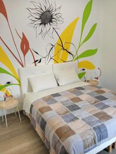 a bedroom with a bed with a flower mural on the wall at Sleep & Fly Villa Luisa in Case Nuove