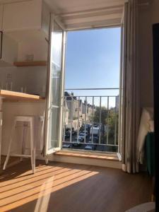 a room with a large window with a view of a city at L'appart des Halles Tours centre in Tours