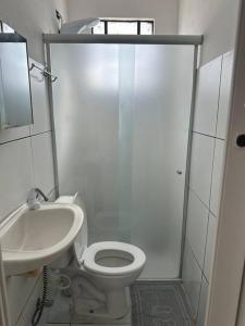 La salle de bains blanche est pourvue de toilettes et d'un lavabo. dans l'établissement Casa de Vó, à Campina Grande