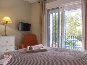 a bedroom with a bed and a balcony with a sliding glass door at Las Palmeras in San José +14 photos