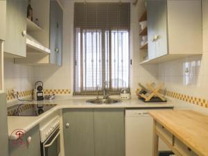 a white kitchen with a sink and a window at Las Palmeras in San José