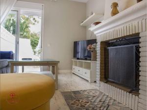 a living room with a fireplace and a tv at Las Palmeras in San José