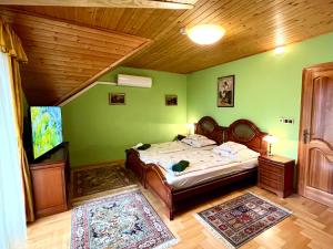 バラトンボグラールにあるKlára Villaの緑の壁のベッドルーム1室(ベッド1台付)
