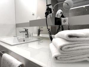 a bathroom with a sink and towels on a counter at Grimm's Potsdamer Platz in Berlin